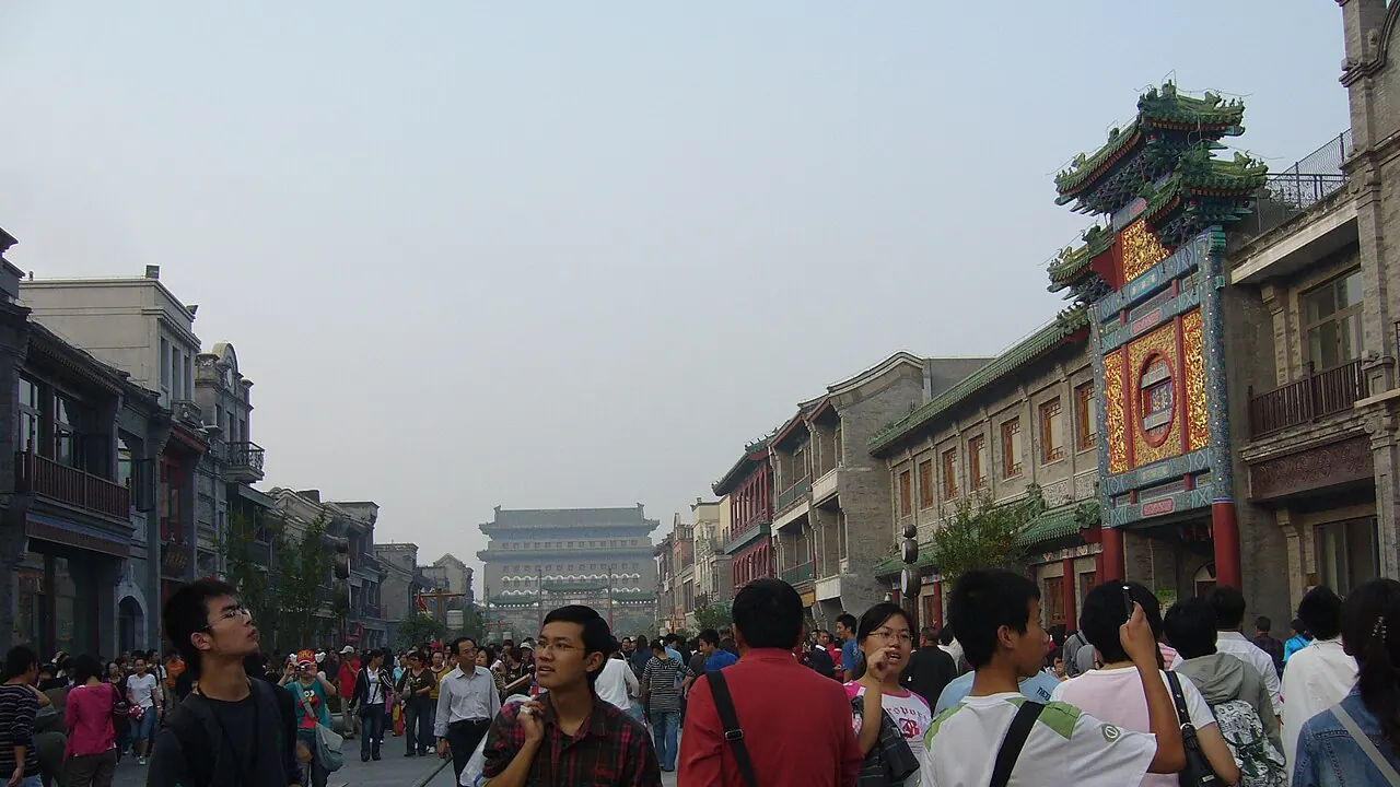 Pedestrians and historic storefronts along Qianmen Street in Beijing